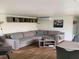 a living room with a couch and a table at Chalet Dune near Dutch Coastline in Koudekerke