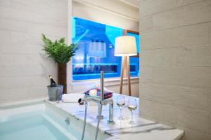 a bathroom with a tub with wine glasses and a lamp at Hotel Vermont Burlington in Burlington