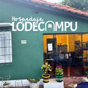 un edificio verde con piante di fronte a un negozio di Lodecampu ad Asunción