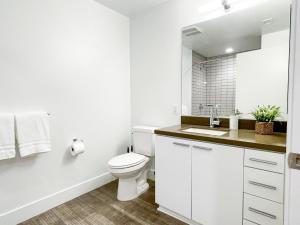 une salle de bain blanche avec toilettes et lavabo dans l'établissement Suite Downtown Pool and Gym Access, à Los Angeles