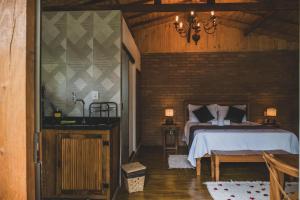 a bedroom with a bed and a brick wall at Chalé pinheirinho in Itamonte