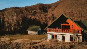 an orange and white house in front of a mountain at Daleko do sufitu - Twój azyl w sercu Gorców in Klodne