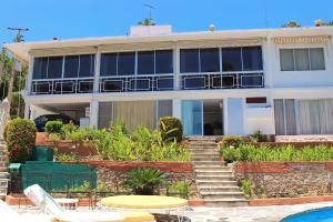 Un edificio con piscina enfrente. en Gran Villa Costa Azul, en Acapulco