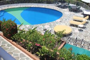 una piscina con sillas y plantas en un patio en Gran Villa Costa Azul, en Acapulco