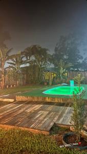 a swimming pool in a backyard with a green yard at Quarto Recanto Monte Trigo in São Francisco do Sul