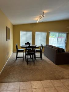 a living room with a table and chairs and a couch at Walking Distance to Stagecoach in Indio