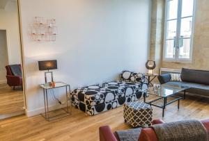 a living room with a couch and a table at Bordeaux Traditions in Bordeaux