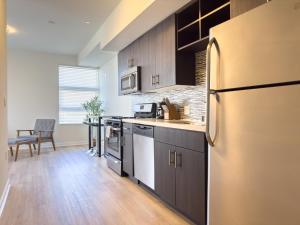 a kitchen with a stainless steel refrigerator and a table at Studio Suite - 5 Min Walk to Crypto Arena and Convention Center in Los Angeles
