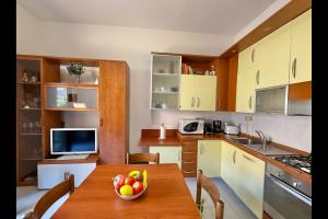 una cucina con un tavolo con una ciotola di frutta sopra di Casa del Limone a Menaggio