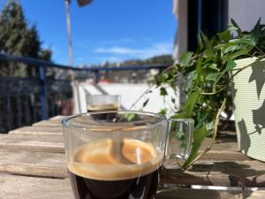 een glas koffie zittend op een tafel bij Near Beach and Easy Parking - By Solstad in Kavala