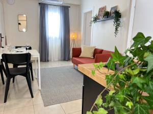 een woonkamer met een rode bank en een tafel bij Near Beach and Easy Parking - By Solstad in Kavala +26 foto's