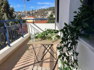 een houten tafel op een balkon met een plant bij Near Beach and Easy Parking - By Solstad in Kavala
