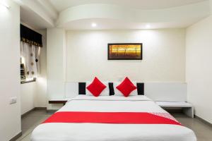 博帕尔Hotel O Mohit Regency的卧室里有一张白色的大床，上面有红色的枕头
