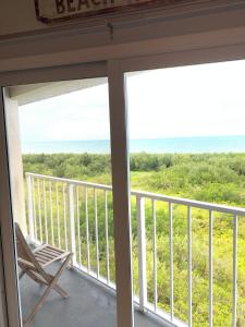 a rocking chair on a balcony with a view of the ocean at Ocean Pointe Resorts 3410 Boho in Tavernier