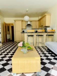 a kitchen with a table with flowers on a checkered floor at Eastenders Guest Home in London