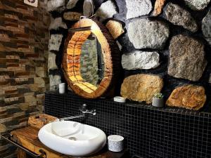 a bathroom with a sink and a stone wall at CABANA ȘTIMA - CAZANELE DUNĂRII -Șvinița in Sviniţa +66 photos