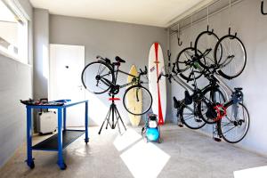 two bikes hanging on a wall next to a surfboard at Bite - Bike and Kite Accommodations in Trapani