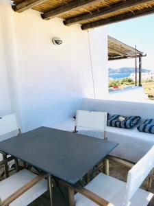 a table and chairs in a room with a couch at EOS - Appartement de charme et confort pour 4 personnes prés de la plage et du coeur de Koufonissi in Koufonisia +30 photos