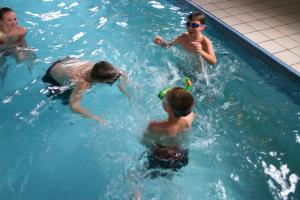 a group of children playing in a swimming pool at Maritime Inn Port Hawkesbury in Port Hawkesbury