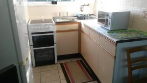 a small kitchen with a stove and a sink at Lovely Chalet 15, Seadell Park in Hemsby