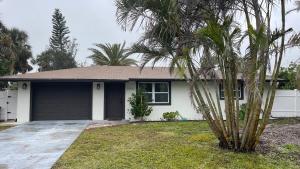 a house with a palm tree in front of it at Venice-Manasota Key Getaway in Venice