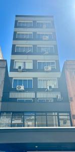 a tall building with cars on the balconies of it at Studio Moderno 401 Santa Casa UFRGS Estacionamento grátis in Porto Alegre