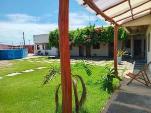 a wooden pole in a yard with grass and flowers at Pousada Canto do Mar Luís Correia in Luis Correia