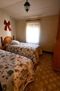 una camera da letto con due letti e una finestra di EVA & TRAVEL - El Cor del Montsant a Ulldemolins