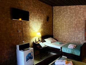 a room with a bed and a desk with a television at CABANA ȘTIMA - CAZANELE DUNĂRII -Șvinița in Sviniţa