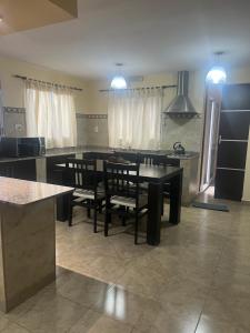 eine Küche mit Tisch und Stühlen und einer Theke in der Unterkunft El Encanto Jujuy 1 in San Salvador de Jujuy