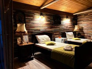 a bedroom with two beds in a room with wooden walls at CABANA ȘTIMA - CAZANELE DUNĂRII -Șvinița in Sviniţa