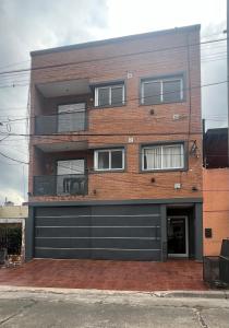 ein Backsteingebäude mit einer schwarzen Garage in der Unterkunft El Encanto Jujuy 1 in San Salvador de Jujuy