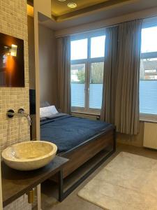 a bedroom with a bed with a sink and a window at Wohnen im Beauty Salon- im Herzen von Greven in Greven