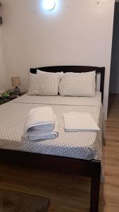 a bed with two sheets and two papers on it at OCEAN VIEW APARTMENTs in Belmont