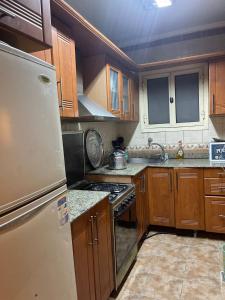 a kitchen with wooden cabinets and a refrigerator at Hamadan Street off Murad Street 400 metres from Nile in Cairo