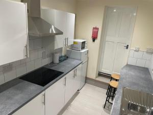 a small kitchen with white cabinets and a microwave at Roseville in Sunderland