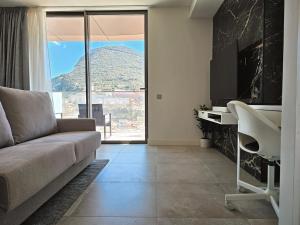 ジブラルタルにある18th Floor Luxury Studioのソファがあり山の景色が見えるリビングルーム