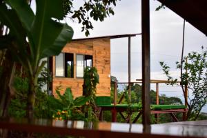 a house with a green bench in front of it at Buena Vista Ecohotel in Los Medios