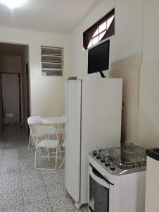 a kitchen with a refrigerator and a stove and a table at Aconchego, Paz , Comodidade e Sucesso in Campos dos Goytacazes