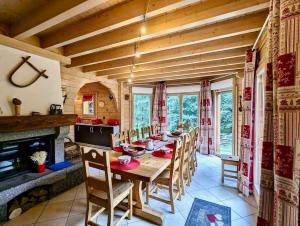 ein Esszimmer mit Tisch und Stühlen und einem Kamin in der Unterkunft Le Murmure du Ruisseau, 4 étoiles avec sauna et terrasse in La Bresse