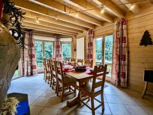 ein Esszimmer mit einem Holztisch und Stühlen in der Unterkunft Le Murmure du Ruisseau, 4 étoiles avec sauna et terrasse in La Bresse + 23 Fotos