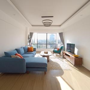 a living room with a blue couch and a tv at Homely and Spacious 2 bed at Marina Bay in Nairobi