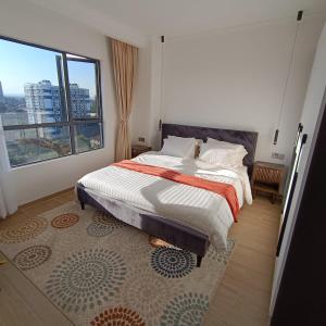 a bedroom with a bed and a large window at Homely and Spacious 2 bed at Marina Bay in Nairobi