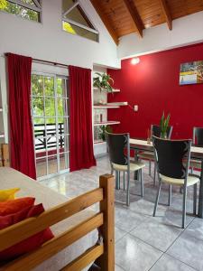 Un comedor con paredes rojas y una mesa y sillas. en AltoRojo, en Villa Elisa