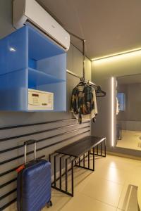 a room with a bench and a blue suitcase at Intercity Salvador in Salvador