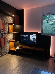 a living room with a flat screen tv on a wall at Villa de charme 4 étoiles avec piscine privée et clim 8 pers près du lac de Parentis in Parentis-en-Born