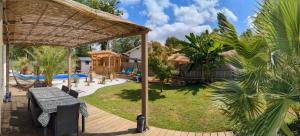 a backyard with a picnic table and a pool at Villa de charme 4 étoiles avec piscine privée et clim 8 pers près du lac de Parentis in Parentis-en-Born