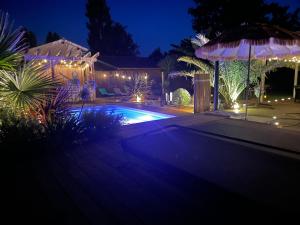 a house with a swimming pool at night at Villa de charme 4 étoiles avec piscine privée et clim 8 pers près du lac de Parentis in Parentis-en-Born
