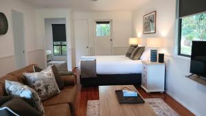 a hotel room with a bed and a couch at The Cottages On Mount Tamborine in Mount Tamborine