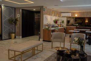 a lobby of a hotel with chairs and a counter at Hilaria in Aguascalientes